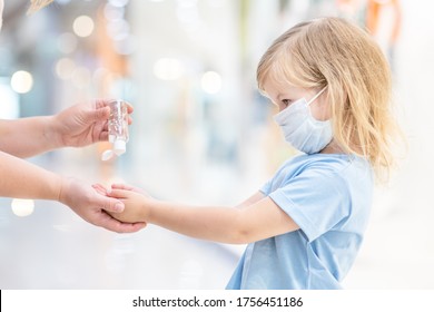 Mother applies sanitizer for cleaning baby hands in public crowded place - Powered by Shutterstock