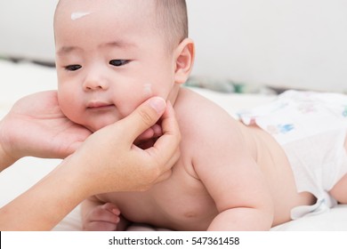 Mother Applying Baby Lotion For Son