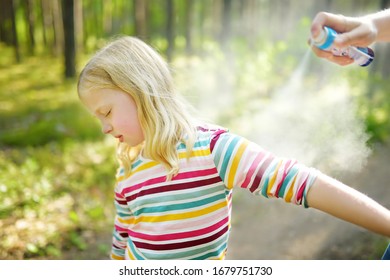 Mother Applying Insect Repellent To Her Daughter Before Forest Hike Beautiful Summer Day. Protecting Children From Biting Insects At Summer. Using Bug Spray. Active Leisure With Kids.