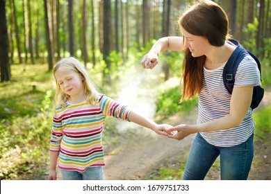 Mother Applying Insect Repellent To Her Daughter Before Forest Hike Beautiful Summer Day. Protecting Children From Biting Insects At Summer. Using Bug Spray. Active Leisure With Kids.