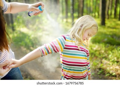 Mother Applying Insect Repellent To Her Daughter Before Forest Hike Beautiful Summer Day. Protecting Children From Biting Insects At Summer. Using Bug Spray. Active Leisure With Kids.