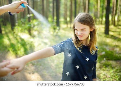 Mother Applying Insect Repellent To Her Daughter Before Forest Hike Beautiful Summer Day. Protecting Children From Biting Insects At Summer. Using Bug Spray. Active Leisure With Kids.