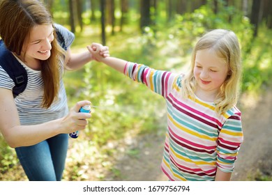 Mother Applying Insect Repellent To Her Daughter Before Forest Hike Beautiful Summer Day. Protecting Children From Biting Insects At Summer. Using Bug Spray. Active Leisure With Kids.