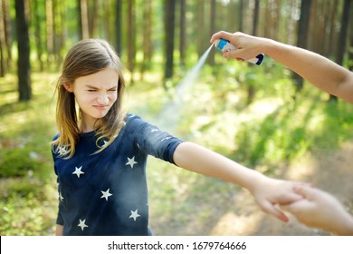 Mother Applying Insect Repellent To Her Daughter Before Forest Hike Beautiful Summer Day. Protecting Children From Biting Insects At Summer. Using Bug Spray. Active Leisure With Kids.