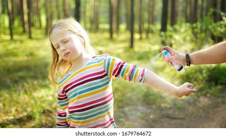 Mother Applying Insect Repellent To Her Daughter Before Forest Hike Beautiful Summer Day. Protecting Children From Biting Insects At Summer. Using Bug Spray. Active Leisure With Kids.