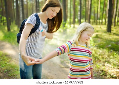 Mother Applying Insect Repellent To Her Daughter Before Forest Hike Beautiful Summer Day. Protecting Children From Biting Insects At Summer. Using Bug Spray. Active Leisure With Kids.