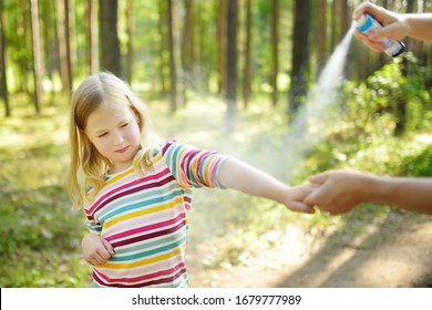 Mother Applying Insect Repellent To Her Daughter Before Forest Hike Beautiful Summer Day. Protecting Children From Biting Insects At Summer. Using Bug Spray. Active Leisure With Kids.