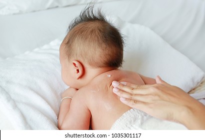 Mother Are Applying A Lotion Cream On The Baby Body After Bath. Baby Care Concept.