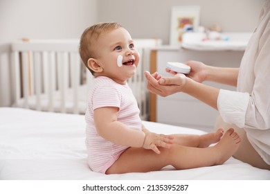 Mother applying moisturizing cream on her little baby at home, closeup - Powered by Shutterstock