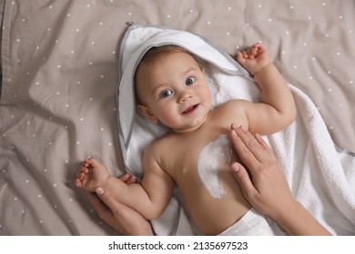 Mother applying moisturizing cream onto her little baby's skin on bed, closeup - Shutterstock ID 2135697523