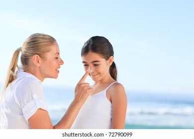 Mother applying sun cream on her daugter's nose - Powered by Shutterstock