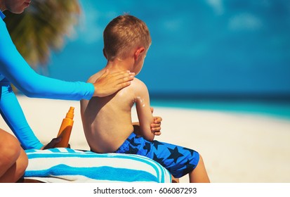 Mother Applying Sunblock Cream On Child Shoulder