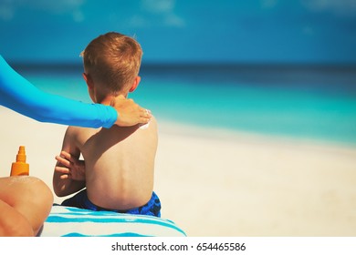 Mother Applying Sunblock Cream On Child Shoulder