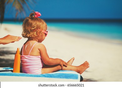 Mother Applying Sunblock Cream On Daughter Shoulder