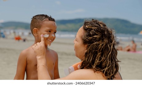 mother applying sunblock lotion on sons skin for sun protection little boy getting ready to swim on the beach with mom using sunscreen caring for childs health on sunny day 
 - Powered by Shutterstock