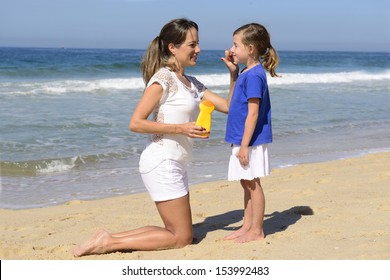 Mother applying sunscreen on child on the beach - Powered by Shutterstock