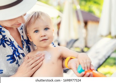 Mother Applying Sunscreen Protection Creme On Cute Little Toddler Boy Face. Mom Using Sunblocking Lotion To Protect Baby From Sun During Summer Sea Vacation. Children Healthcare At Travel Time.