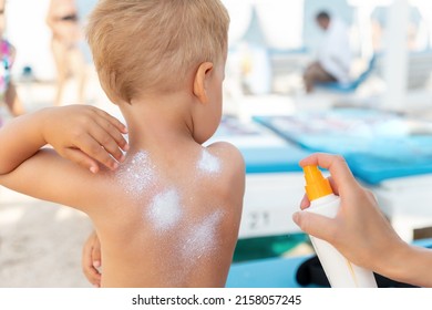 Mother applying sunscreen protection creme on cute little baby boy kid hand. Mum using sunblocking lotion to protect baby from sun during summer sea vacation. Child healthcare travel vacation time