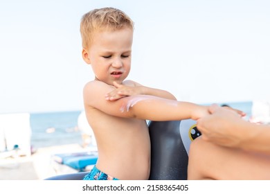 Mother Applying Sunscreen Protection Creme On Cute Little Baby Boy Kid Face. Mum Using Sunblocking Lotion To Protect Baby From Sun During Summer Sea Vacation. Child Healthcare Travel Vacation Time