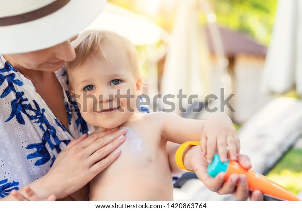 かわいい幼い男の子の顔に日焼け止め防止クリームを塗った母 夏の海休みに日焼け止めローションを使って赤ちゃんを日焼けから守る母親 旅行時の子ども向け医療 の写真素材 今すぐ編集