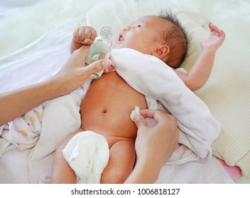 Mother Applying Vanishing Cream For Infant To Prevent Stomachache. Baby Have A Stomach Ache.