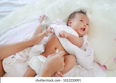 Mother Applying Vanishing Cream For Infant To Prevent Stomachache. Baby Have A Stomach Ache.