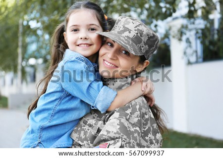 Mother in army uniform and daughter in the street