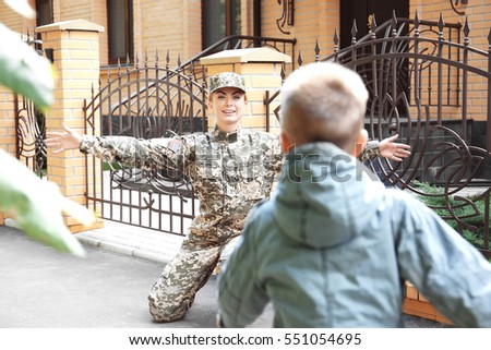 Mother in army uniform meeting her son on street