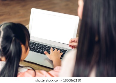 Mother And Asian Kid Little Girl Learning And Looking At Laptop Computer Making Homework Studying Knowledge With Online Education E-learning System.children Video Conference With Teacher Tutor At Home