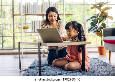 Mother And Asian Kid Little Girl Learning And Looking At Laptop Computer Making Homework Studying Knowledge With Online Education E-learning System.children Video Conference With Teacher Tutor At Home