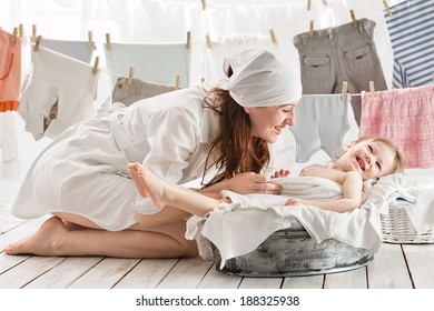 Mother With Baby In A Basin Clothes In The Laundry