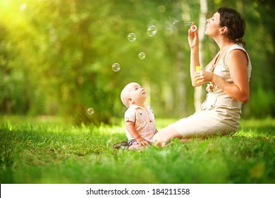 Mother and baby blowing bubbles in the park. - Powered by Shutterstock