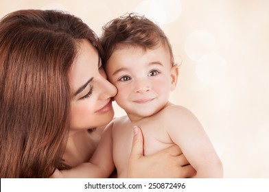 Mother And Baby Boy Closeup Portrait, Happy Faces Over Beige Background,  Mom And Kid Having Fun Indoor, Parents Lifestyle, Woman Holding Little Child, Healthy Toddler And Mommy, Happiness Concept