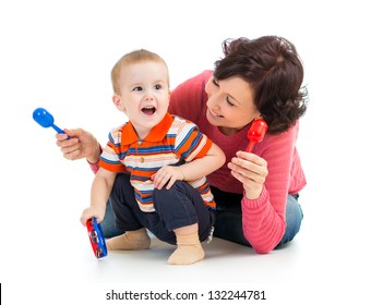 Mother and baby boy having fun with musical toys. Isolated on white background