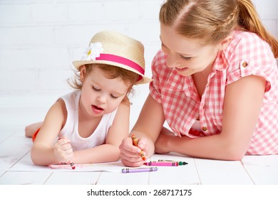 mother and baby daughter together paint a kid pencils