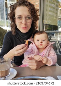 Mother And Baby Eating Churros In Malaga Spain