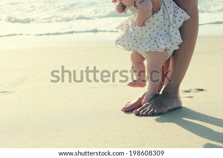 mother and baby feet at the beach sand
