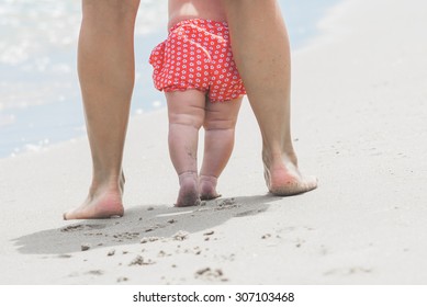 Mother And Baby Feet Walking On Sand Beach