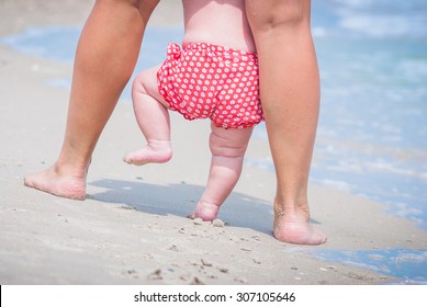 Mother And Baby Feet Walking On A Sand Beach