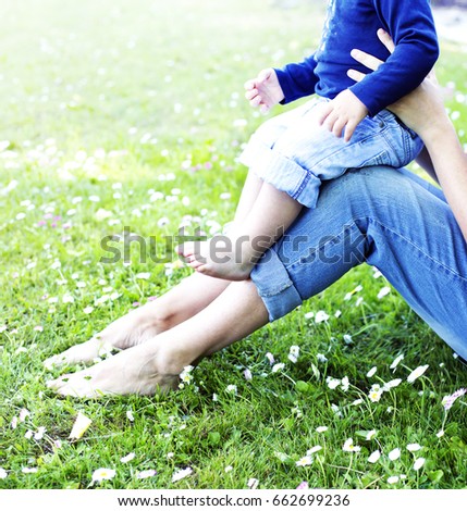 Mother and baby feet walking on grass