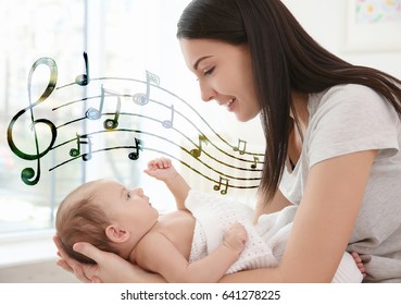 Mother With Baby At Home. Lullaby Songs And Music Concept