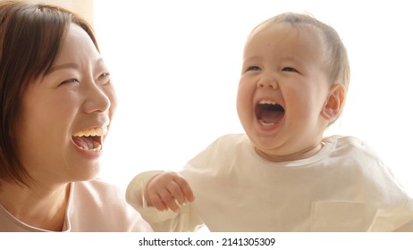 mother and baby laughing in the living room