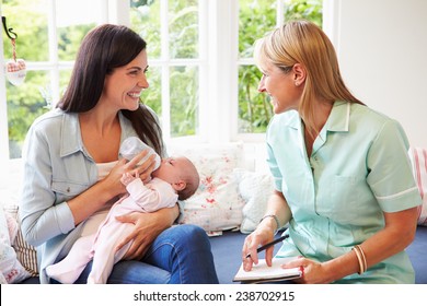 Mother With Baby Meeting With Health Visitor At Home
