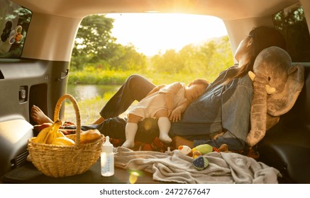 Mother and baby napping in the trunk during a car trip - Powered by Shutterstock