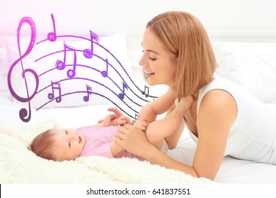 Mother With Baby On Bed. Lullaby Songs And Music Concept