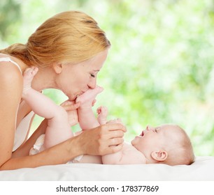 Mother With Baby Outdoors. Happy Family With Newborn In Summer