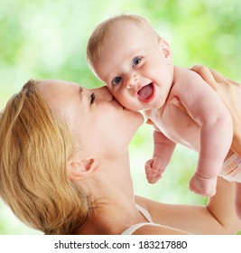 Mother With Baby Outdoors. Happy Family With Newborn In Summer