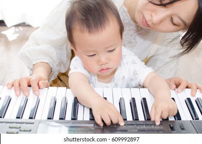 Mother And Baby Playing The Piano