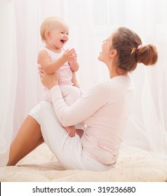 Mother And Baby Playing And Smiling. Happy Family.Home Interior.