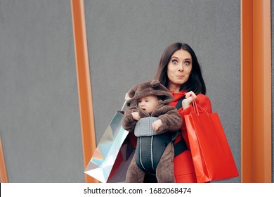 Mother And Baby Shopping At The Mall. Happy Mom Taking Infant Out For A Walk And For Shopping
